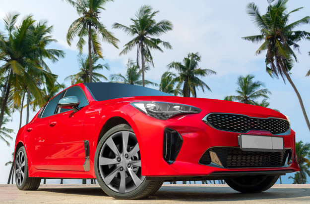 Red car with palm trees in the background